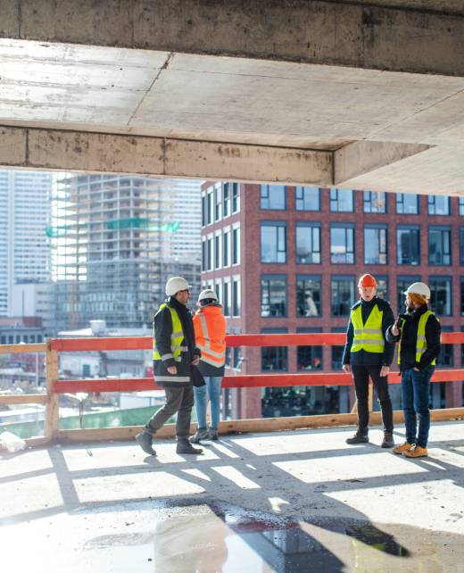 Group of engineers standing on construction site, talking. A group of engineers standing on construction site, talking.
